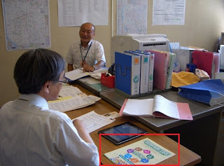 事務所の様子。机上にパンフレット。