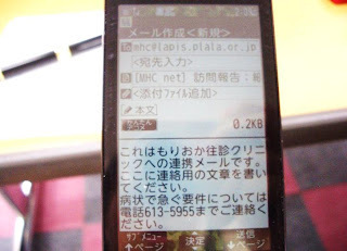 携帯のメール作成画面。「これはもりおか住診クリニックへの連絡メールです。ここに連絡用の文章を書いてください」と記載されている