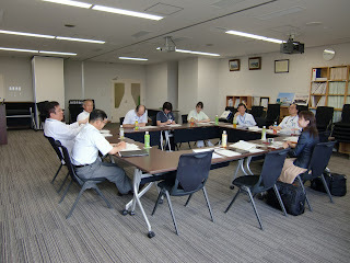 会議室で9名が着席している