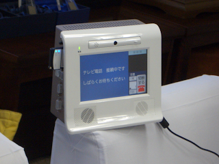 テレビ電話システム。「接続中、しばらくお待ちください」と表示。