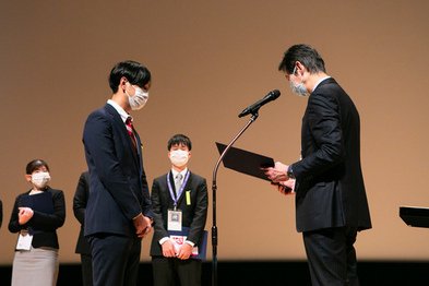 黒田主任研究員が表彰されている写真